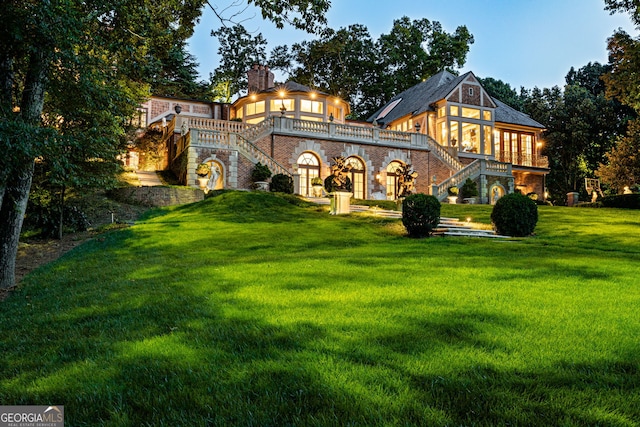 rear view of house featuring a lawn