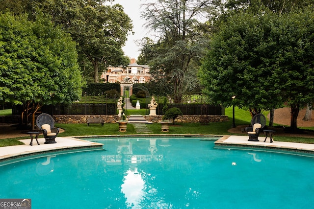 view of swimming pool with a lawn