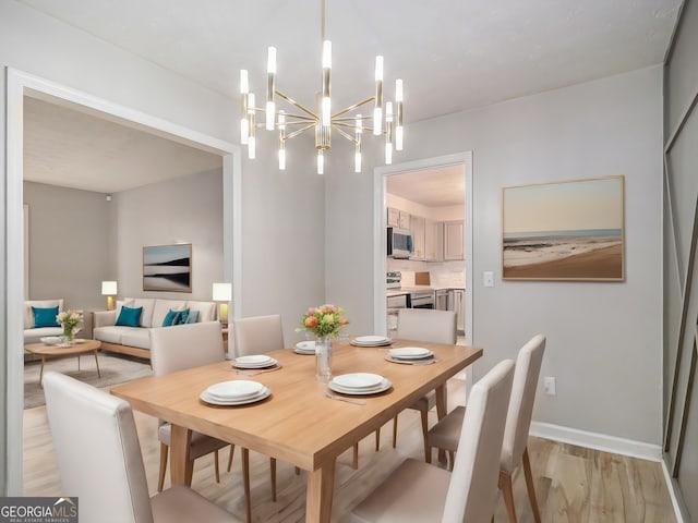 dining space with light hardwood / wood-style flooring and a notable chandelier