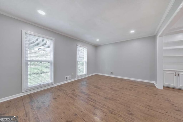 empty room featuring light hardwood / wood-style flooring and ornamental molding