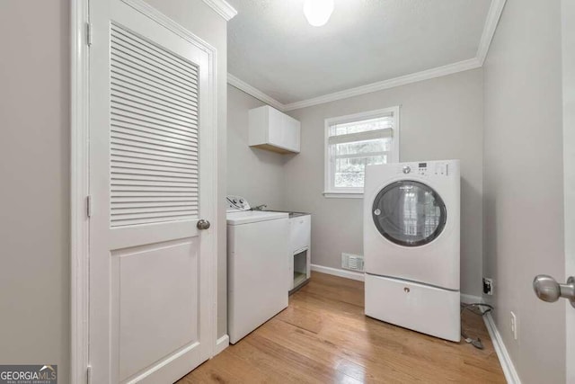 washroom with independent washer and dryer, ornamental molding, cabinets, and light wood-type flooring