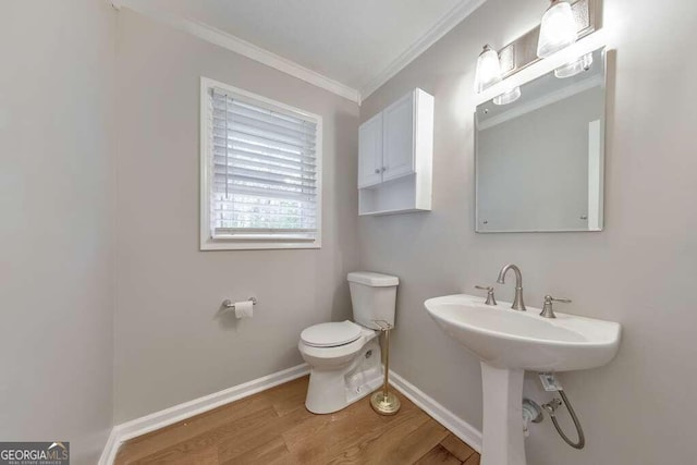 bathroom with hardwood / wood-style flooring, ornamental molding, and toilet