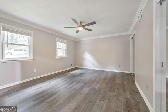 empty room with ceiling fan, crown molding, and wood-type flooring