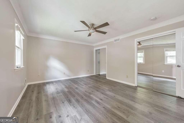 empty room with ceiling fan, hardwood / wood-style floors, and crown molding