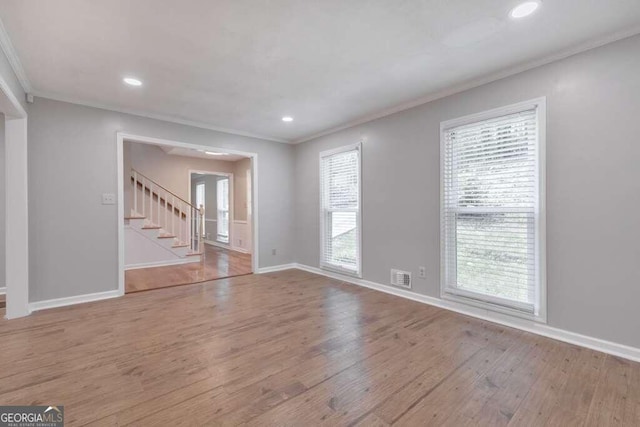 spare room with crown molding and hardwood / wood-style flooring