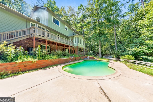 view of pool featuring a wooden deck and a patio area