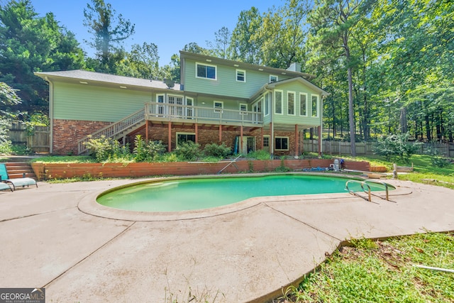 view of pool featuring a wooden deck and a patio