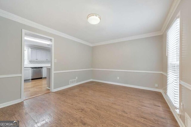 spare room featuring light hardwood / wood-style flooring and ornamental molding