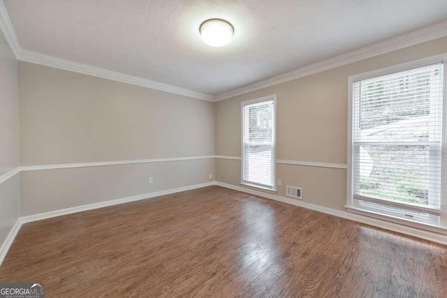 spare room with hardwood / wood-style flooring and crown molding