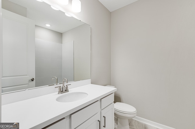 bathroom featuring vanity, toilet, and a shower