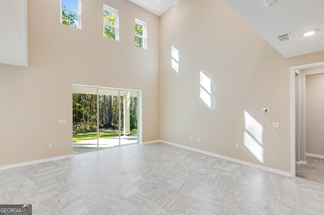 unfurnished living room featuring a high ceiling