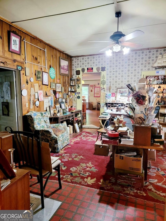 miscellaneous room with ceiling fan and wooden walls