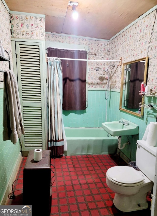 full bathroom with sink, shower / bath combination with curtain, tile walls, and toilet