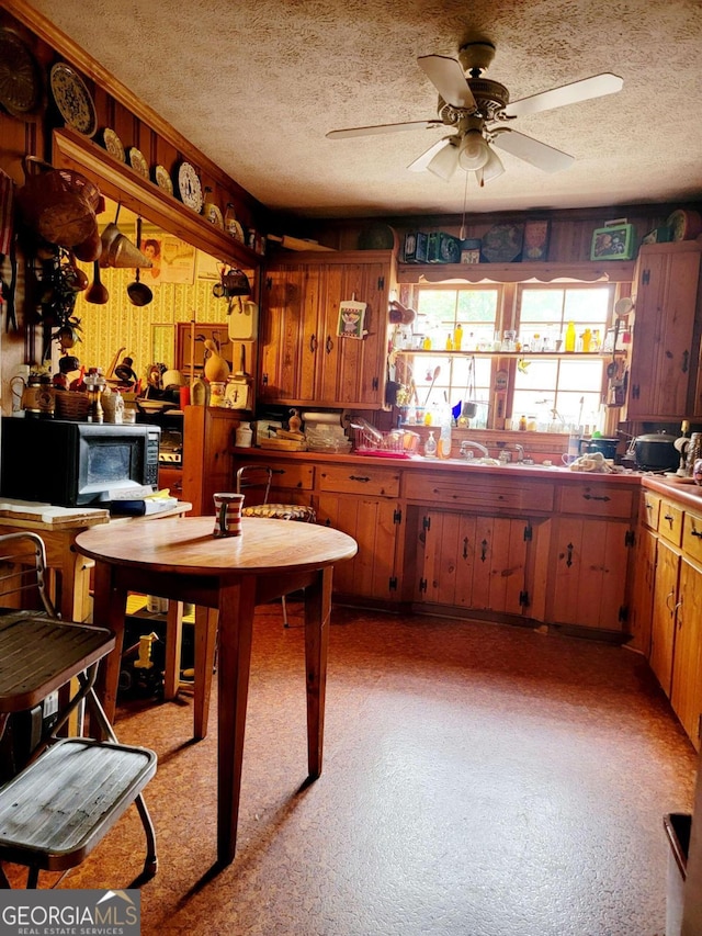 kitchen with ceiling fan and a textured ceiling