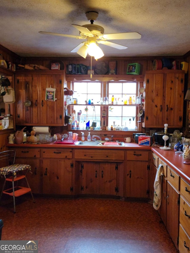 kitchen featuring a textured ceiling, ceiling fan, and sink