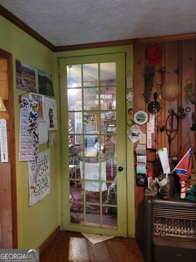 doorway featuring ornamental molding and a textured ceiling