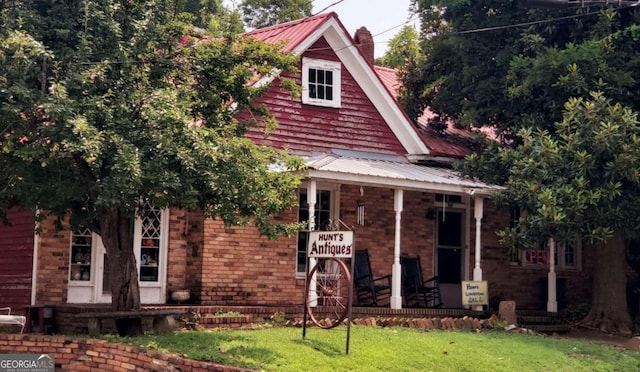 view of front of house featuring covered porch and a front lawn