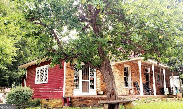 view of side of home featuring covered porch