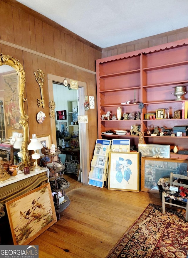 interior space featuring wood-type flooring, built in shelves, and wood walls