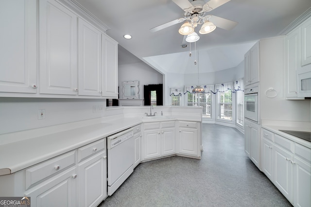 kitchen with sink, white appliances, ceiling fan, kitchen peninsula, and white cabinets