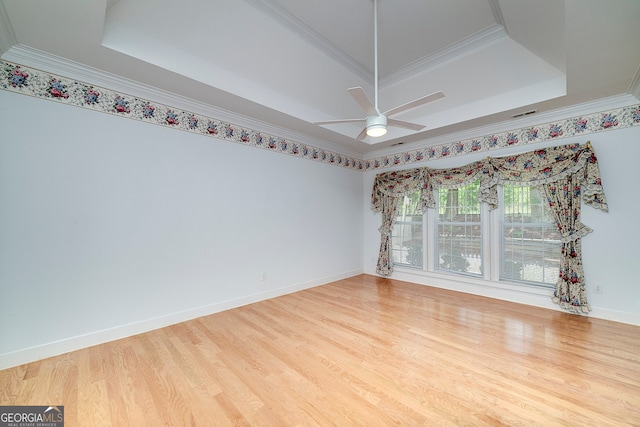 unfurnished room featuring ceiling fan, a raised ceiling, crown molding, and wood-type flooring