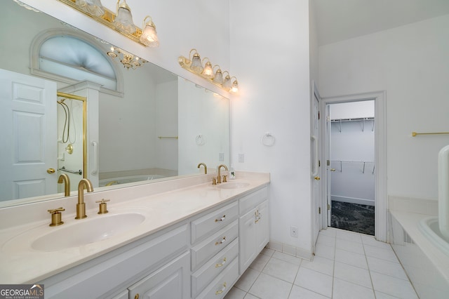 bathroom with a bath, double sink vanity, and tile patterned flooring