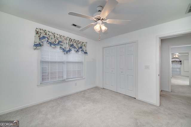 unfurnished bedroom featuring ceiling fan, carpet flooring, and a closet