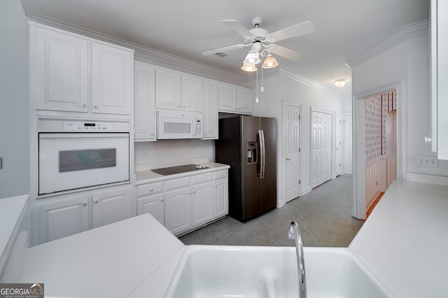 kitchen featuring white appliances, ceiling fan, white cabinets, and light colored carpet