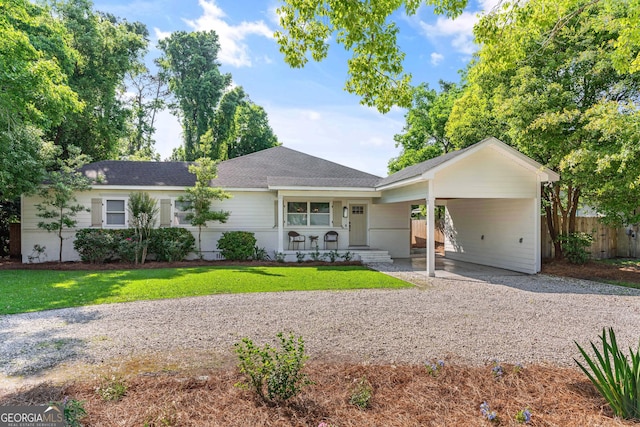 ranch-style house with a carport, covered porch, and a front lawn