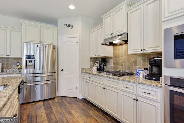 kitchen featuring white cabinetry, dark wood-type flooring, appliances with stainless steel finishes, and tasteful backsplash