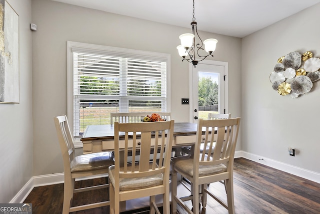 dining room featuring a healthy amount of sunlight, dark hardwood / wood-style floors, and a notable chandelier