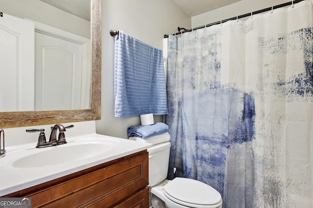 bathroom featuring a shower with shower curtain, vanity, and toilet