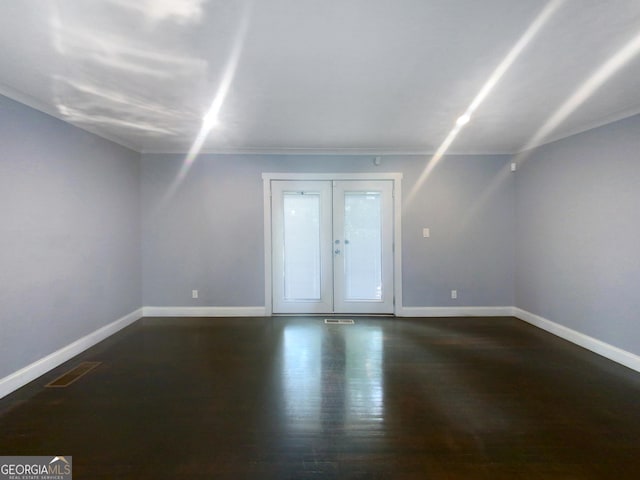 unfurnished room featuring french doors, dark hardwood / wood-style floors, and ornamental molding