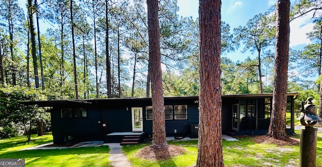 ranch-style home featuring a front yard and central AC