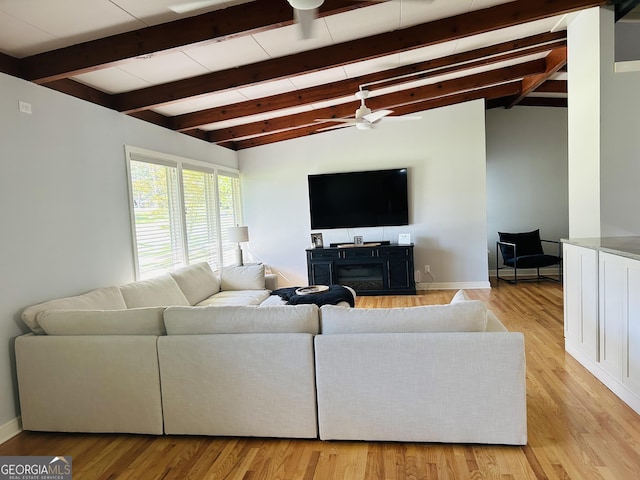 living room with vaulted ceiling with beams, ceiling fan, and light hardwood / wood-style flooring