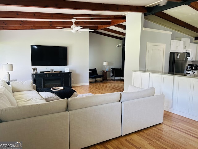 living room featuring ceiling fan, light hardwood / wood-style flooring, and vaulted ceiling with beams