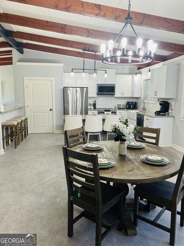 dining room with vaulted ceiling with beams and a chandelier