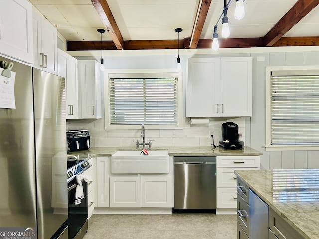 kitchen featuring sink, white cabinetry, hanging light fixtures, appliances with stainless steel finishes, and light stone countertops