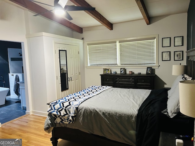 bedroom with beamed ceiling and light hardwood / wood-style floors