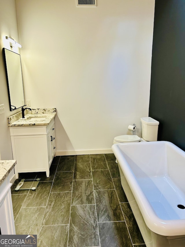 bathroom with vanity, toilet, and a bathing tub