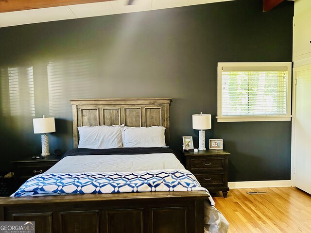 bedroom with light hardwood / wood-style flooring and lofted ceiling