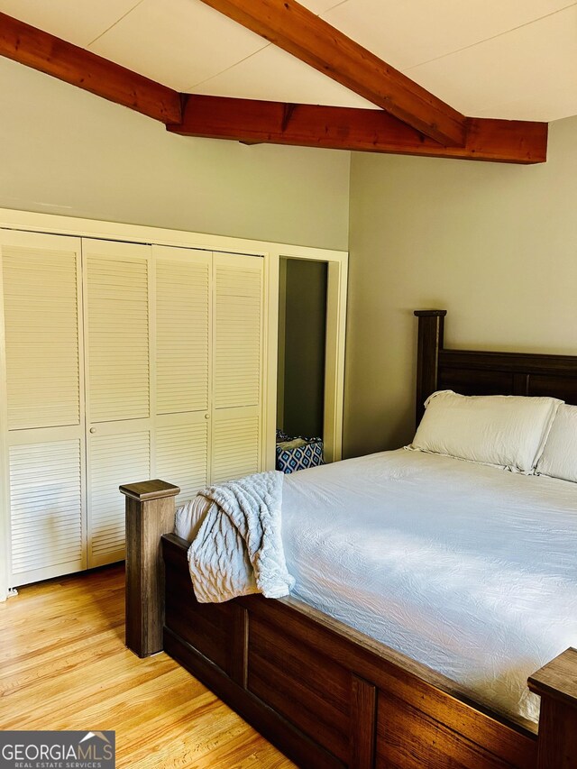 bedroom with beam ceiling and light hardwood / wood-style flooring