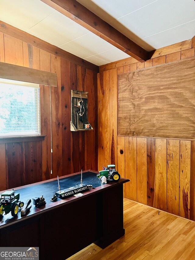 rec room featuring beamed ceiling, wood-type flooring, and wood walls