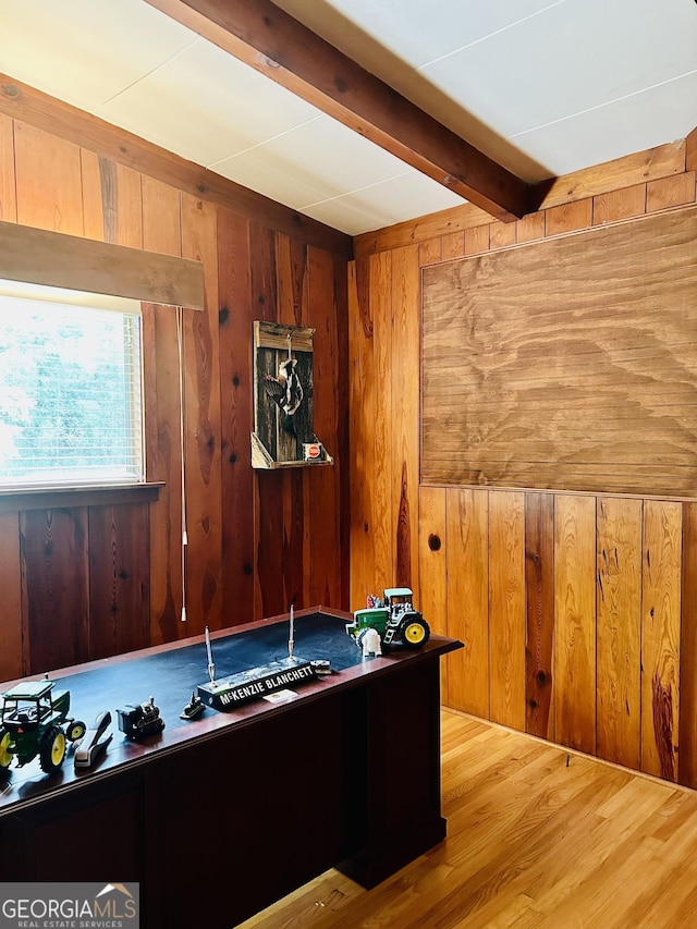 interior space with wood-type flooring, beamed ceiling, and wood walls