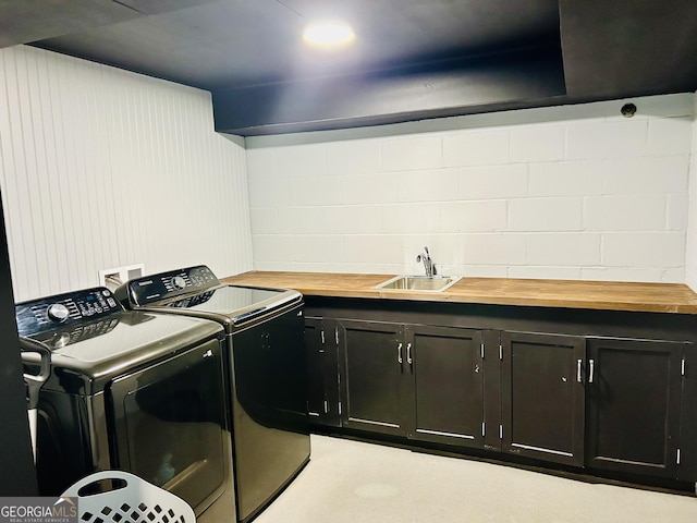 laundry area featuring cabinets, separate washer and dryer, and sink