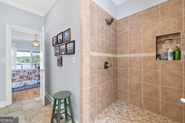 bathroom featuring ceiling fan, ornamental molding, and a tile shower