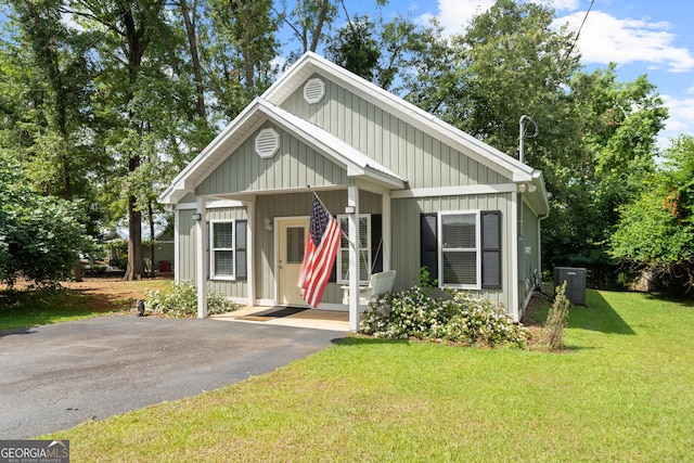 view of front of house with a front lawn and cooling unit