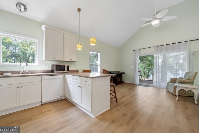 kitchen featuring dishwasher, decorative light fixtures, white cabinetry, sink, and kitchen peninsula