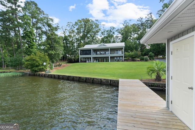 view of dock with a yard and a water view