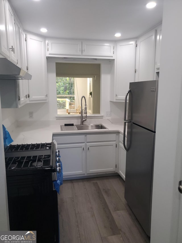 kitchen featuring sink, dark hardwood / wood-style floors, white cabinetry, black / electric stove, and stainless steel refrigerator